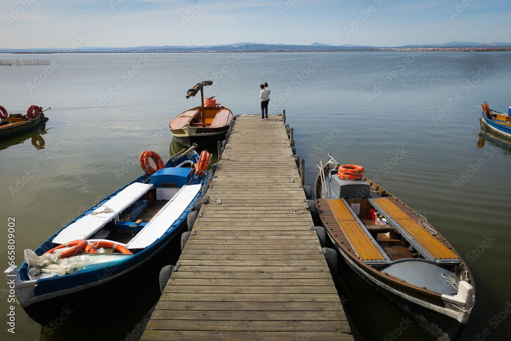 Father holding son in his arms in wooden dock by Albufera lake in Valencia 