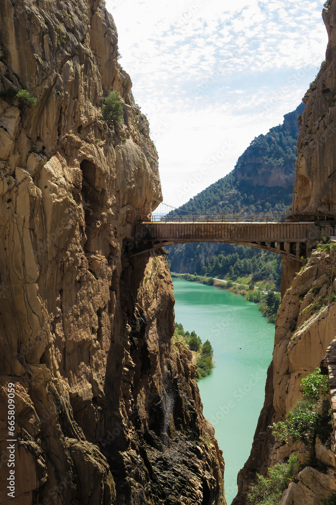 Fototapeta premium View of wooden bridge by cliffs and lake in El camito del Rey