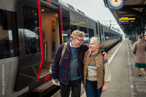 Happy senior couple going to their train at the station photo