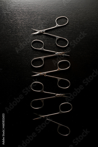 Manicure open scissors close-up on stand with black background