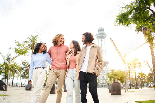 Cheerful group of friends walk in the park of the tourist city. People having fun, youth culture, city lifestyle. High quality photo