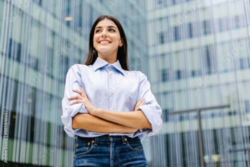 Foto Confidence portrait of young businesswoman standing over office building