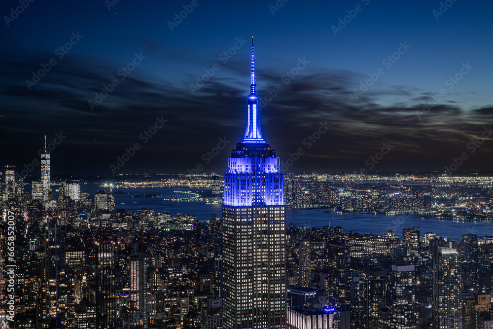 Obraz premium Tourist view of new york city at night, summit vanderbilt building perspective, empire state building and east river