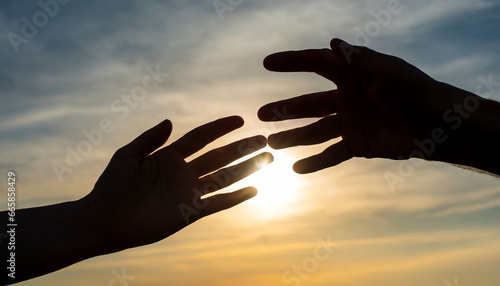silhouettes of hands reaching out for hope and supporting each other on sunset background
