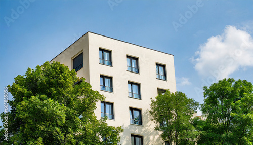 a modern residential building in the vicinity of trees ecology and green living in city urban environment concept modern apartment building and green trees ecological housing architecture © Enzo
