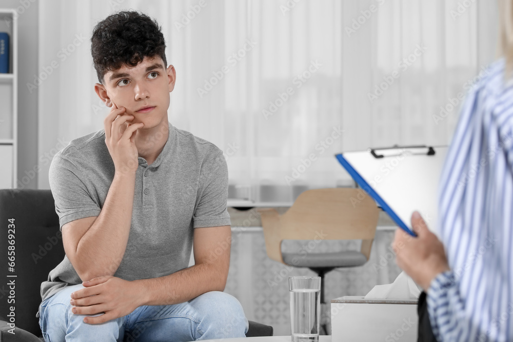 Obraz premium Psychologist working with teenage boy in office. Teenager problems