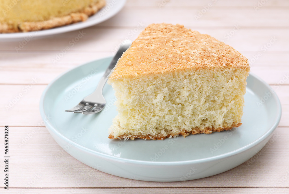 Piece of tasty sponge cake on white wooden table, closeup Piece of tasty sponge cake on white wooden table, closeup