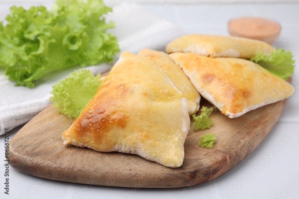 Delicious samosas and lettuce on white table, closeup Delicious samosas and lettuce on white table, closeup