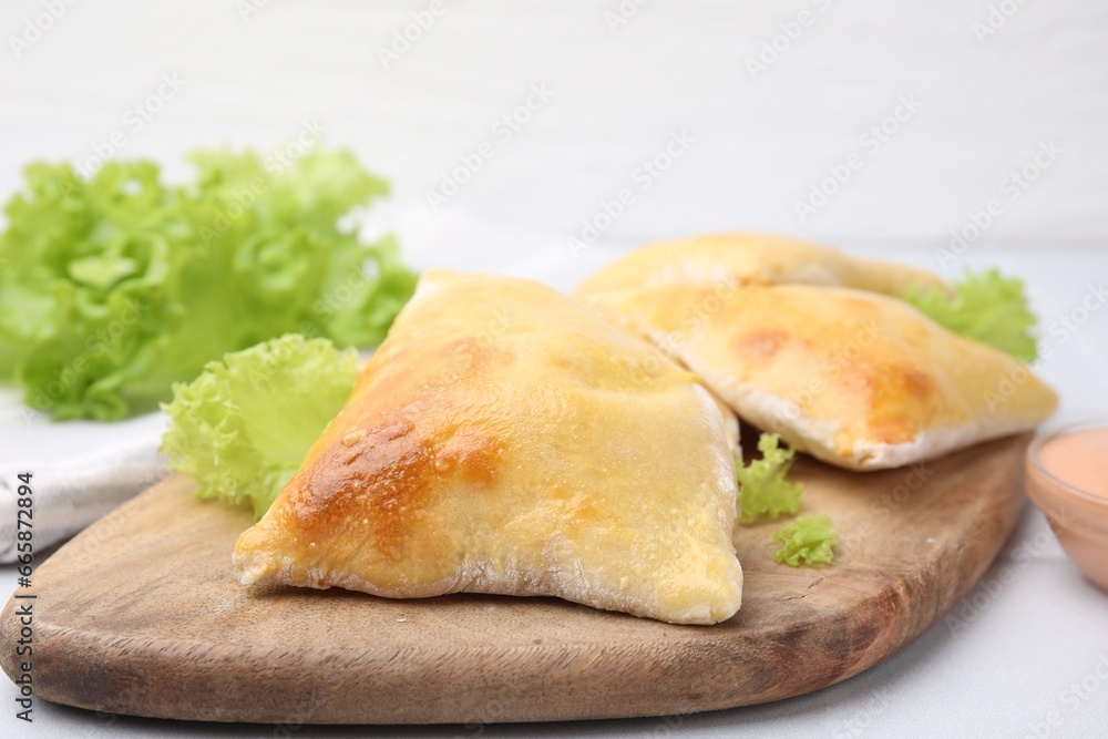 Delicious samosas and lettuce on white table, closeup Delicious samosas and lettuce on white table, closeup