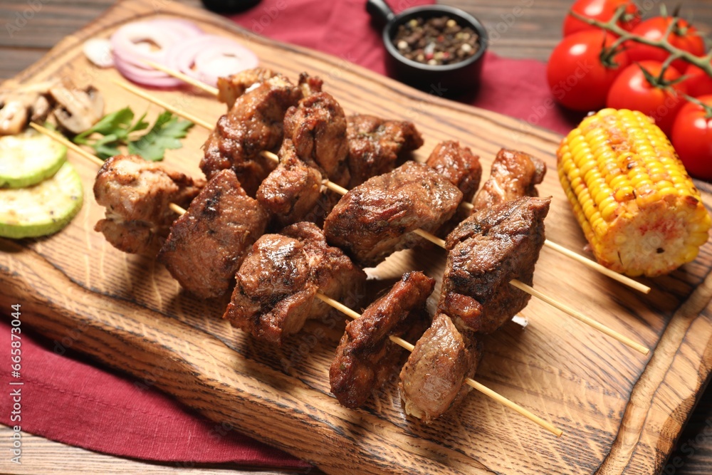 Delicious shish kebabs with vegetables on table Delicious shish kebabs with vegetables on table