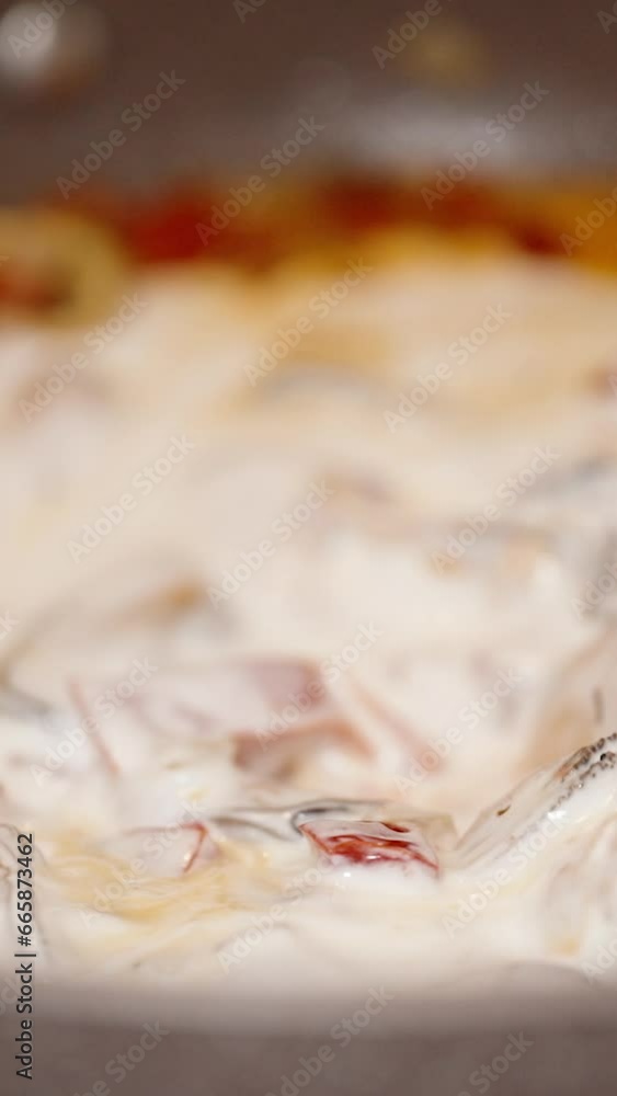 Vertical video. I Stir Mussels in Creamy Sauce with Vegetables Using a Wooden Spoon, Close-Up. Vertical video. I Stir Mussels in Creamy Sauce with Vegetables Using a Wooden Spoon, Close-Up.