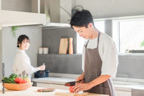 キッチンで料理・家事をする若いアジア人夫婦・カップル（自炊・共働き・朝食・ランチ） 
