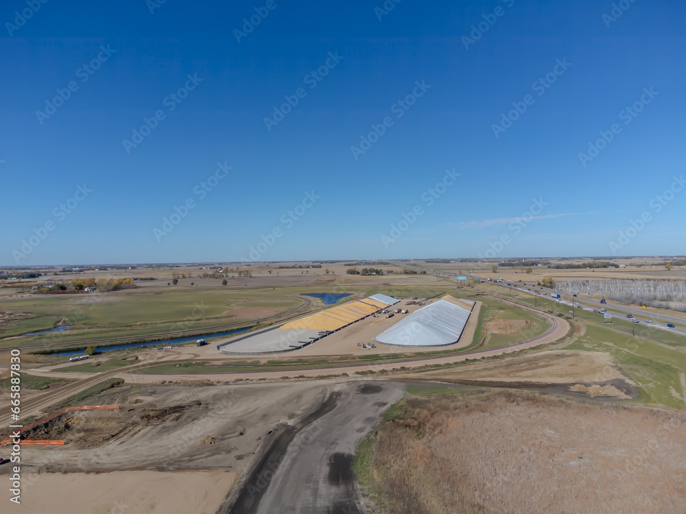 Drone view over two grain storage piles being filled and covered