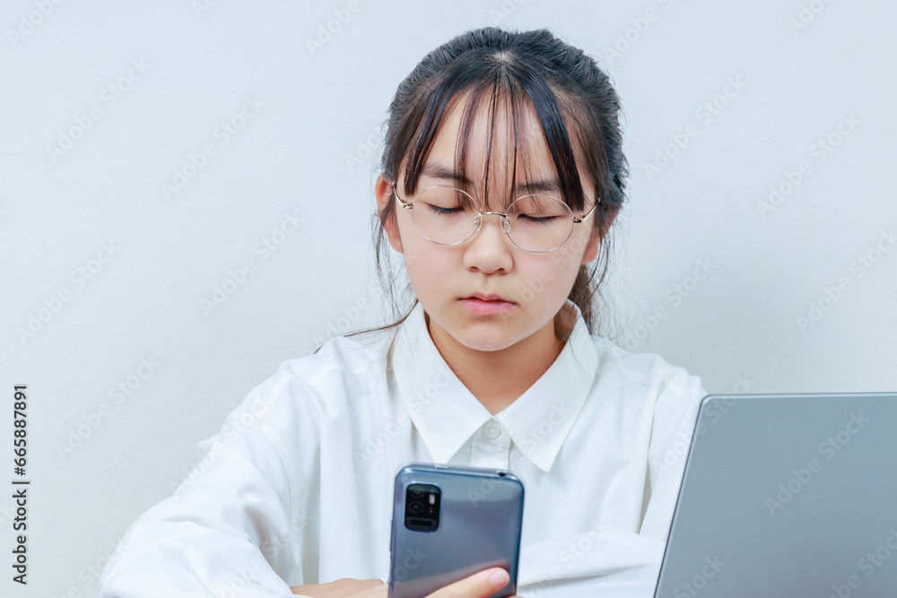 	学習中にスマホを持って居眠りをする女子