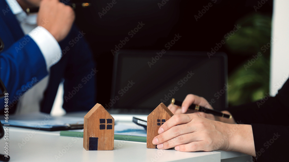 Fototapeta premium Female woman hands holding home model, small miniature white toy house. Mortgage property insurance dream moving home and real estate concept