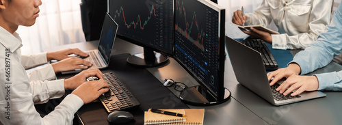 Fotografija Group of traders discussing on office desk, monitoring stock market on monitor at office workplace