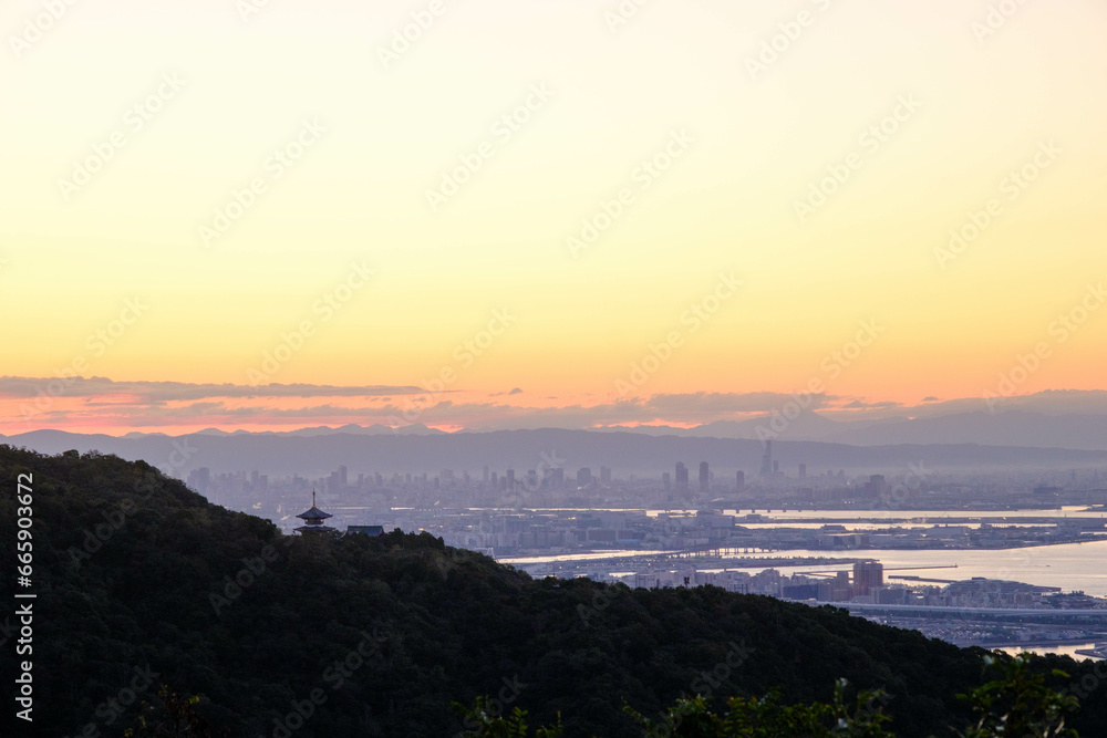 神戸市の高台渦森台展望公演からの夜明け。やまなみから太陽が昇り雲がオレンジ色に輝く。