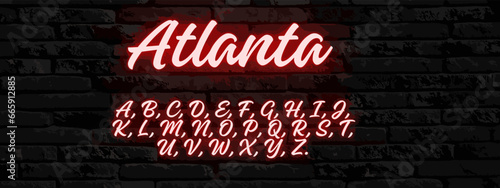 A neon text of Atlanta on a dark grey brick background with the alphabet.