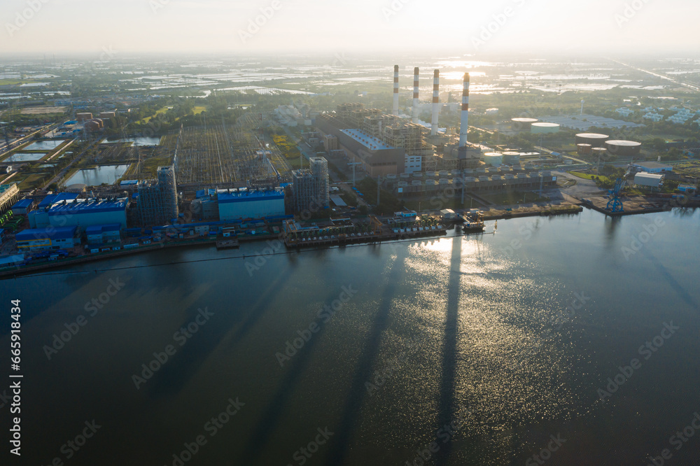 Aerial view Bang Pakong power plant of gas power plant, Thermal power plants and fuel oil, electrical power plant. energy concept, morning sky, container ship, freight transportation,
