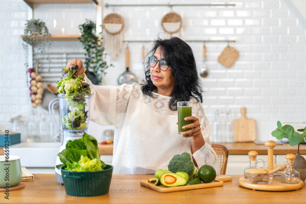 Portrait senior healthy asian woman making green vegetables detox cleanse and green fruit smoothie with blender.elderly woman drinking glass of green fruit smoothie in kitchen.healthcare, insurance.