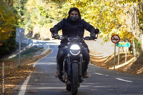 Man riding motorcycle on the road  autumn scenery
