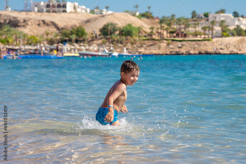 Adorable child playing in the sea on the mediterranean beaches