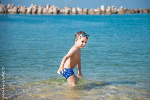 Adorable child playing in the sea on the mediterranean beaches