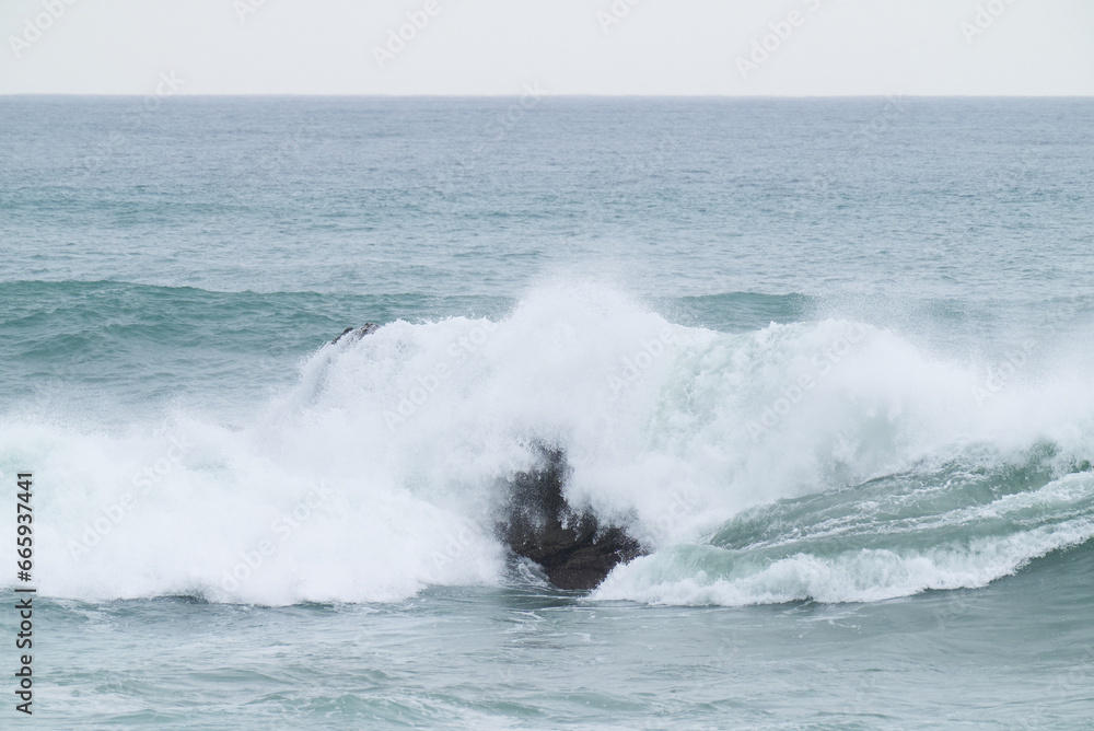 波に飲み込まれる岩