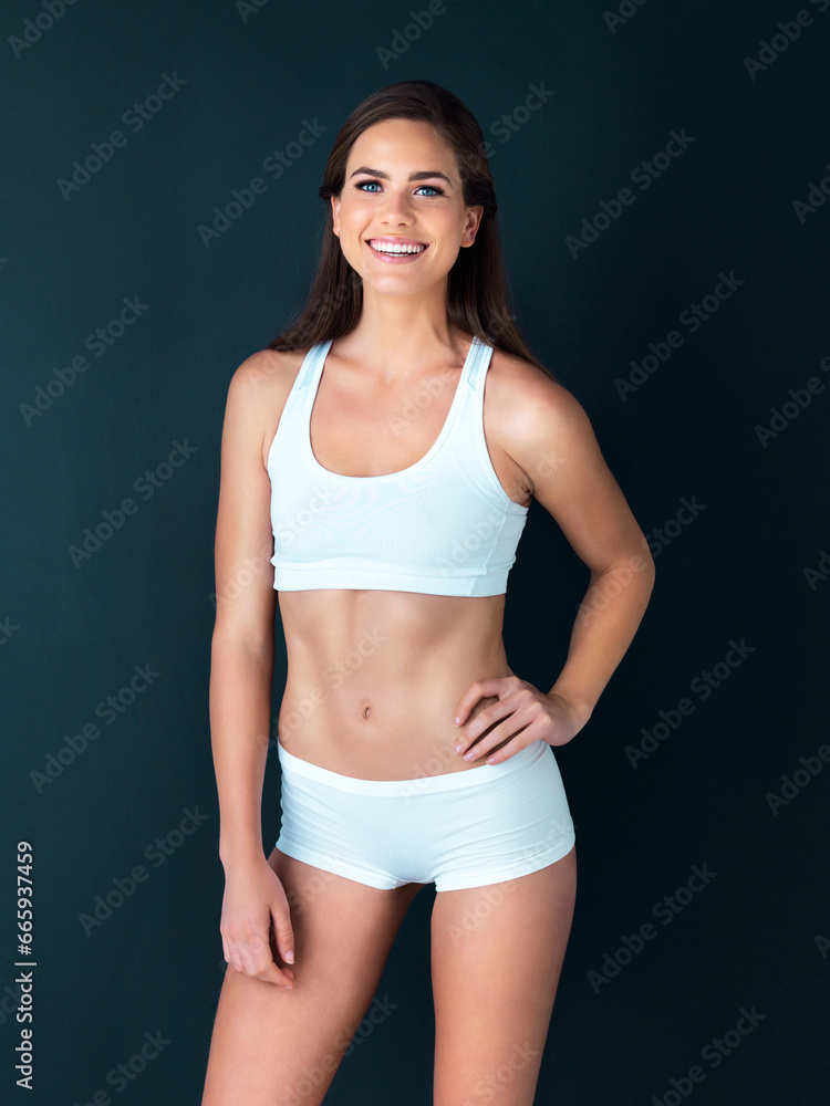 Fototapeta premium Happy woman, portrait and fitness to lose weight, health and wellness against a studio background. Active female person smile with hand on hip for body workout, exercise or training on mockup space
