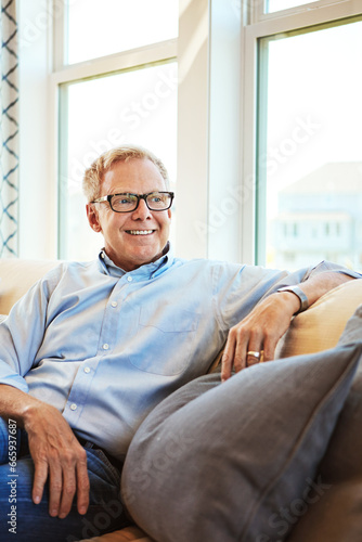 Thinking, mature or happy man in living room to relax with ideas on sofa or couch at home for resting. Calm, glasses or senior male person with smile, peace or wellness in retirement, lounge or house © Grady Reese/peopleimages.com
