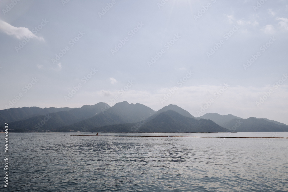 Mountains and water view from the ferry to Miyajima (Miyajimacho) Island. Mountains and water view from the ferry to Miyajima (Miyajimacho) Island.