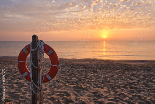 Post with lifeguard float on the beach shore