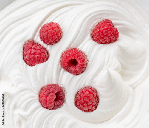 Fresh raspberries in the yoghurt or cream. Top view.