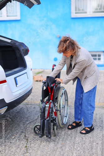 Woman folding wheelchair in a car