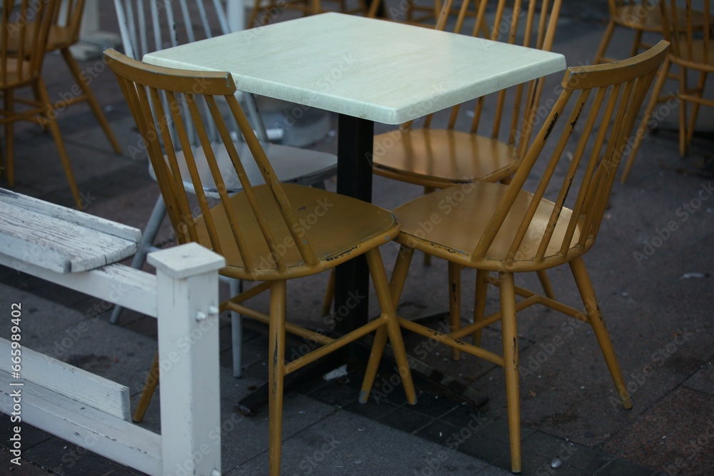Yellow and white chairs and tables in the cafe outside, retro style