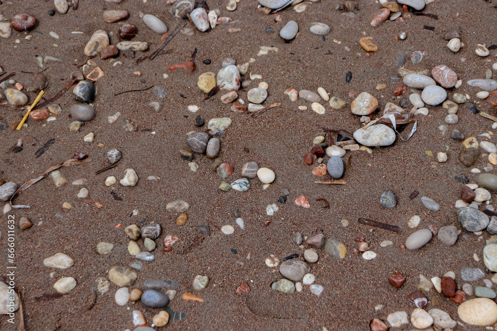 Abstract background beach sand with pebble rocks on the ground at Paralia Ixia beach off Rhodes city Abstract background beach sand with pebble rocks on the ground at Paralia Ixia beach off Rhodes city