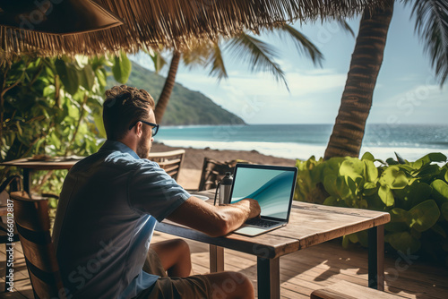 A man working on a laptop while overlooking a picturesque tropical beach, embracing the freedom of location-independent work