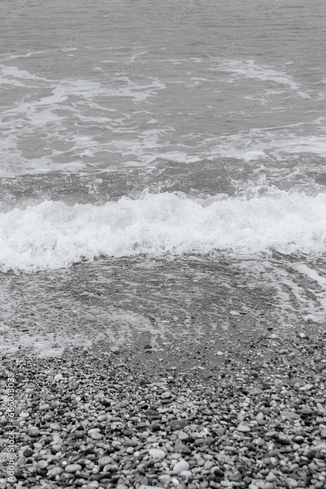 Obraz premium Clear water washing up on the shore at Paralia Ixia beach off Rhodes city in black and white