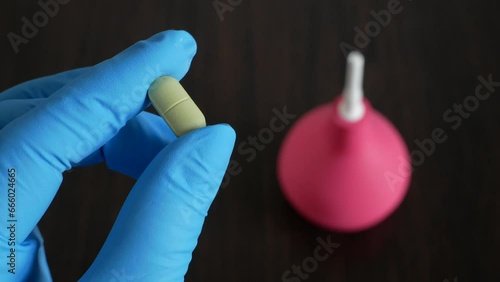 Wallpaper Mural hand holding  pills on enema  on wooden background, enema vs pills for treatment  from intestinal constipation Torontodigital.ca