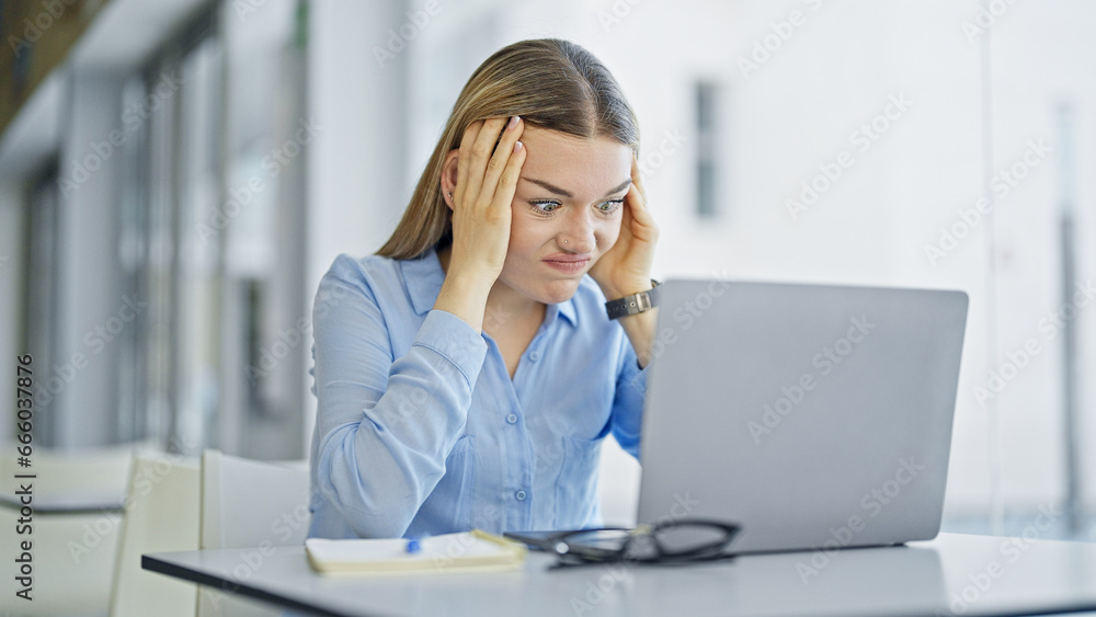 Young blonde woman business worker using laptop working stressed at office Young blonde woman business worker using laptop working stressed at office