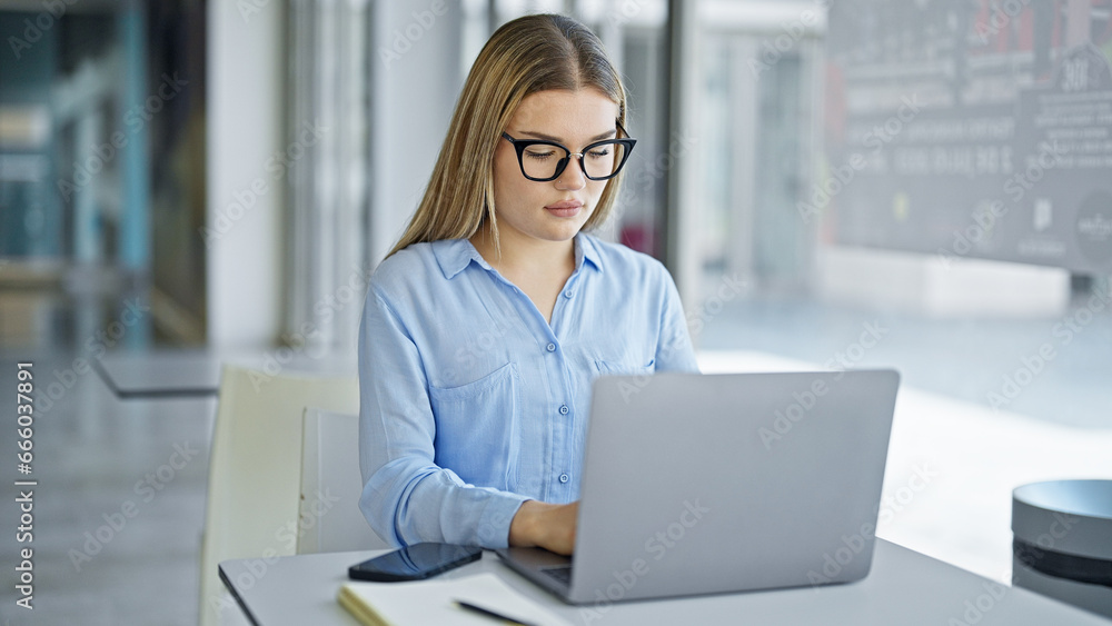 Young blonde woman business worker using laptop working at office Young blonde woman business worker using laptop working at office