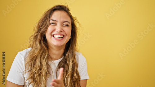 Vászonkép Young beautiful hispanic woman laughing a lot standing over isolated yellow back