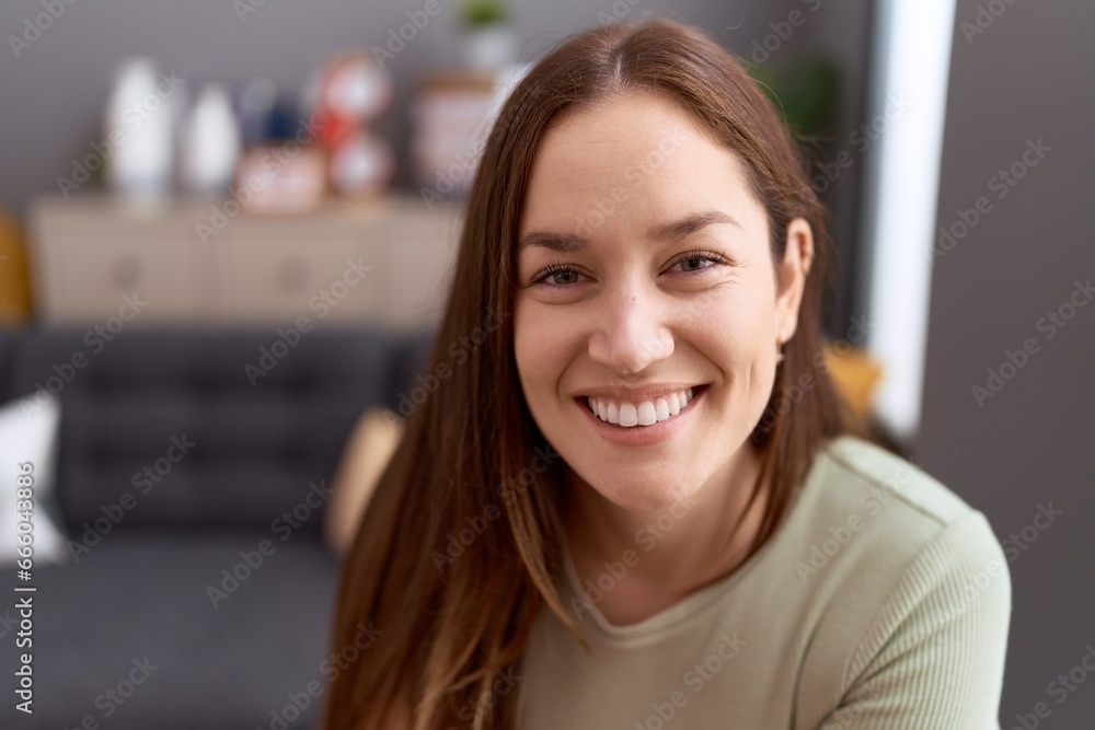 Young beautiful woman smiling confident sitting on sofa at home