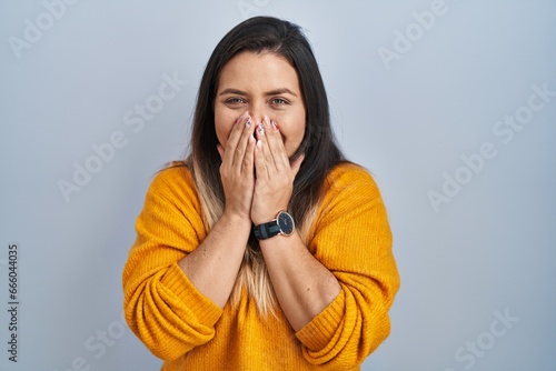 Принти на полотні Young hispanic woman standing over isolated background laughing and embarrassed