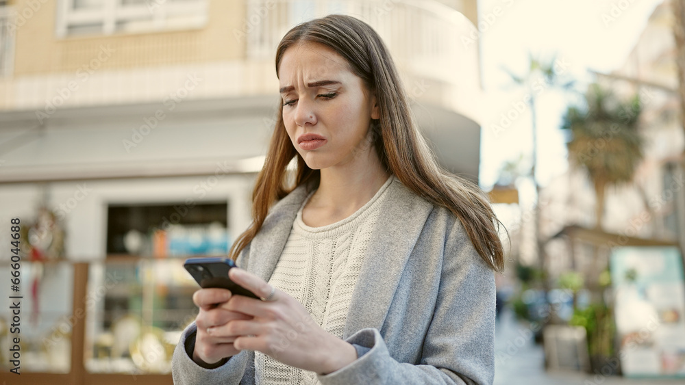 Young hispanic woman using smartphone looking upset at coffee shop terrace Young hispanic woman using smartphone looking upset at coffee shop terrace