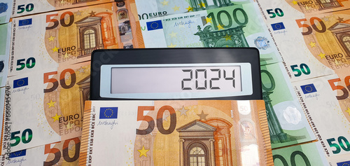 New challenges in 2024. Calculator on the background of 50 and 100 euro banknotes. Inflation, economic crisis, elections, war, recession, bankruptcy, cost of living, bills, poverty, migrants