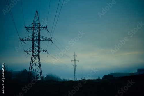 High-voltage tower and power lines at dusk