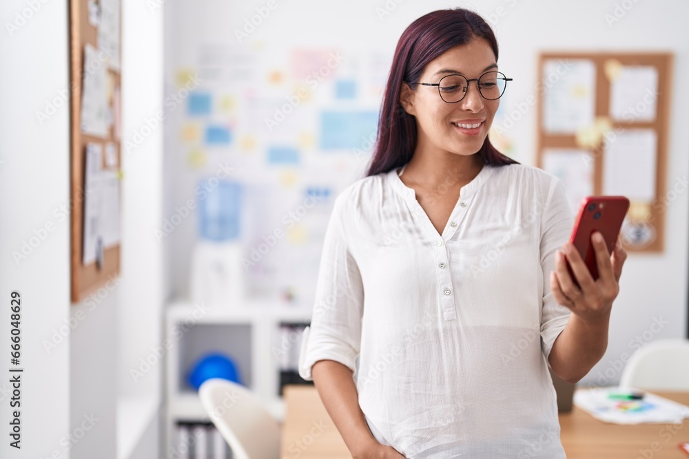 Young beautiful hispanic woman business worker smiling confident using smartphone at office Young beautiful hispanic woman business worker smiling confident using smartphone at office