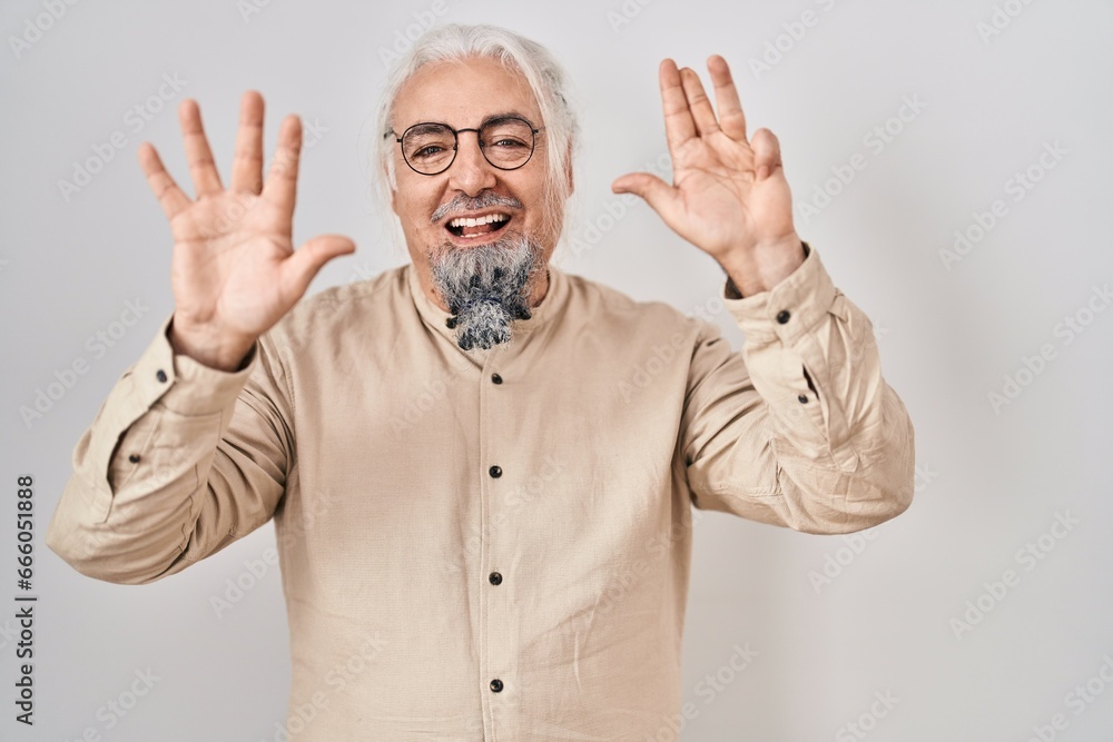 Middle age man with grey hair standing over isolated background showing and pointing up with fingers number nine while smiling confident and happy. Middle age man with grey hair standing over isolated background showing and pointing up with fingers number nine while smiling confident and happy.