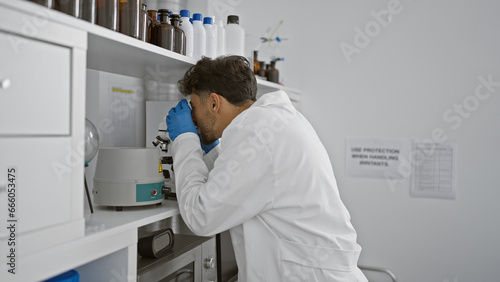 Wallpaper Mural Young arab man scientist using microscope at laboratory Torontodigital.ca